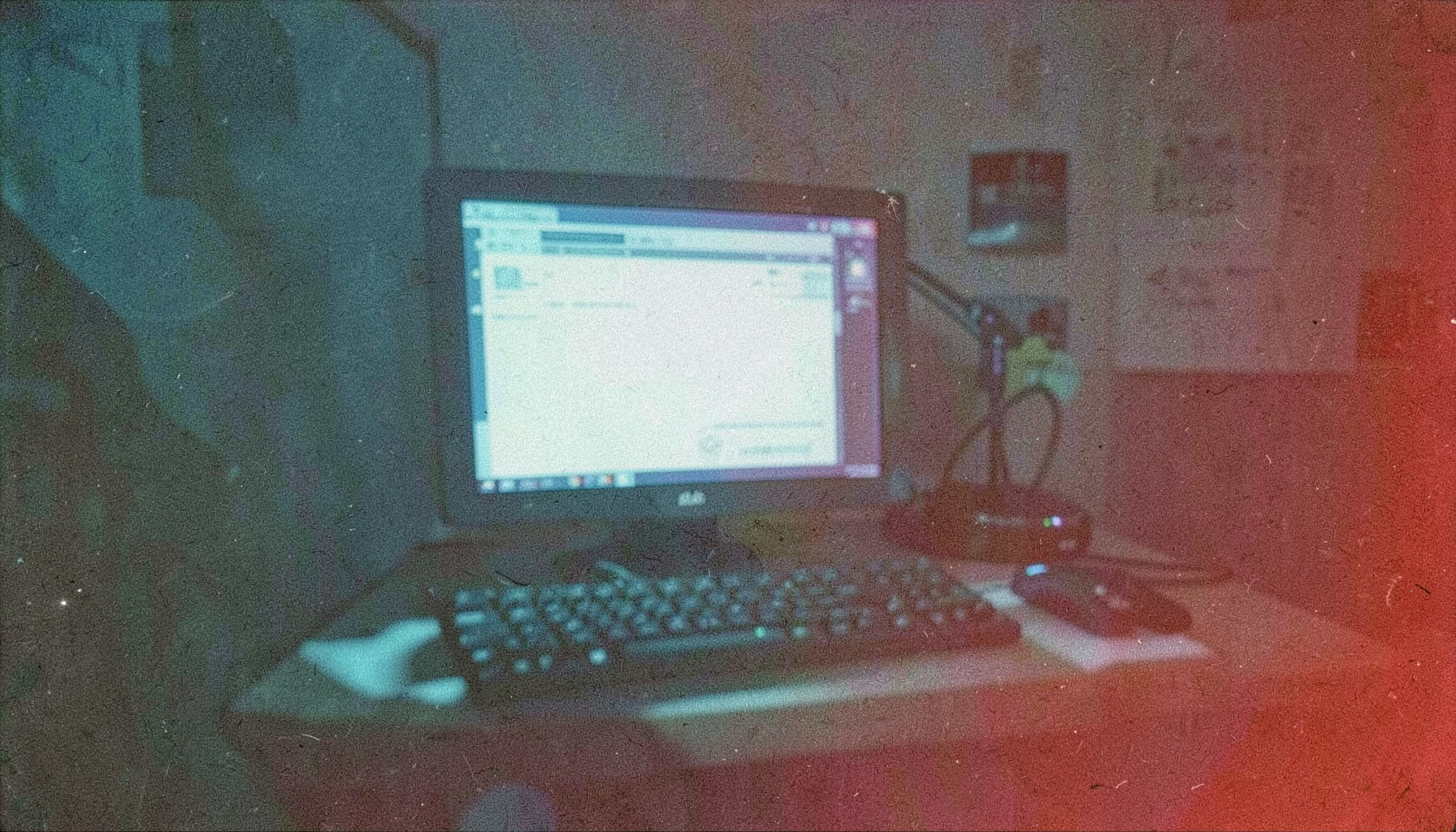 Grainy analog photograph of a motion design workstation, cool blue and teal tones with subtle screen glow