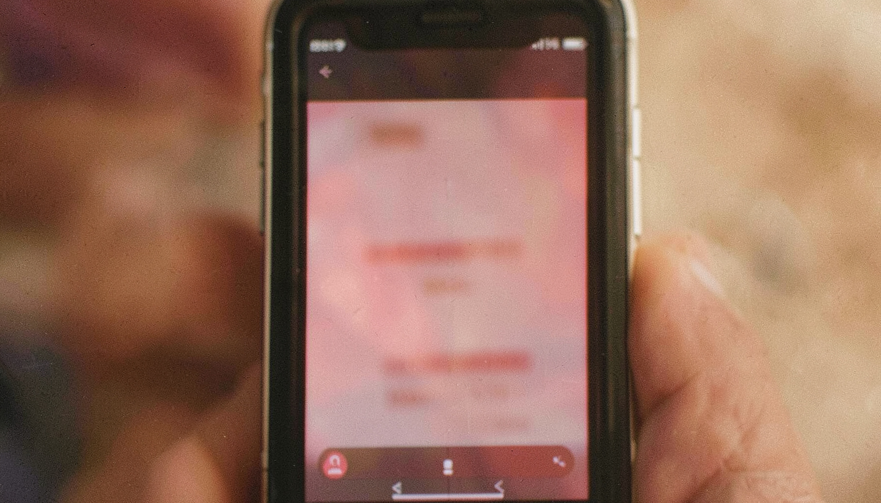 Close-up of a smartphone screen displaying vertical video content, soft natural light with warm tones